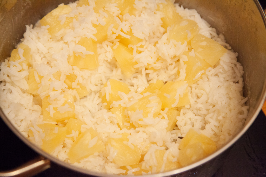 Basmati-Reis wird mit Ananasstücken gemischt.
