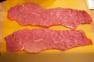 Das Fleisch für die Rinderrouladen wird gesalzen und gepfeffert.