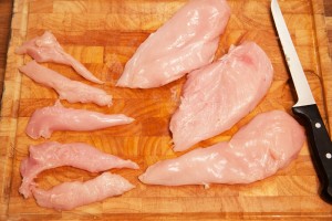 Die Hühnerbrustfilets werden mit einem scharfen Messer von Sehnen und Fett befreit.
