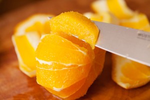 Die Orangenfilets werden mit einem scharfen Messer herausgelöst.