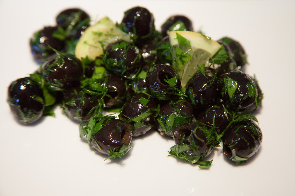 Eine Portion eingelegte-Oliven-mit-frischem-Dill-und-Petersilie.