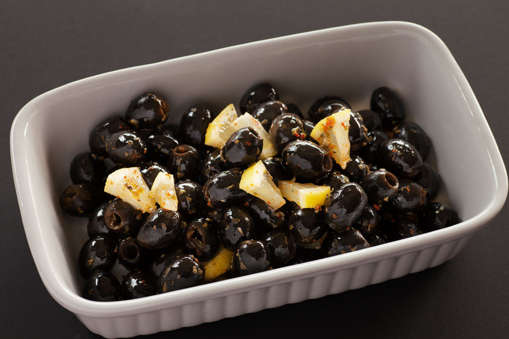 Eingelegte schwarze Oliven mit Zitrone, Chili und Oregano.