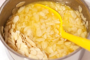 Für den Belag werden flüssige Butter, Zucker und Mandeln vermischt.