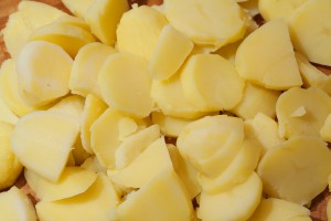 Gekochte Kartoffeln werden in Scheiben geschnitten.
