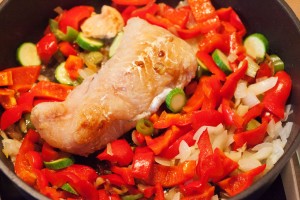 Gemüse und Fisch werden für die Paella angebraten.