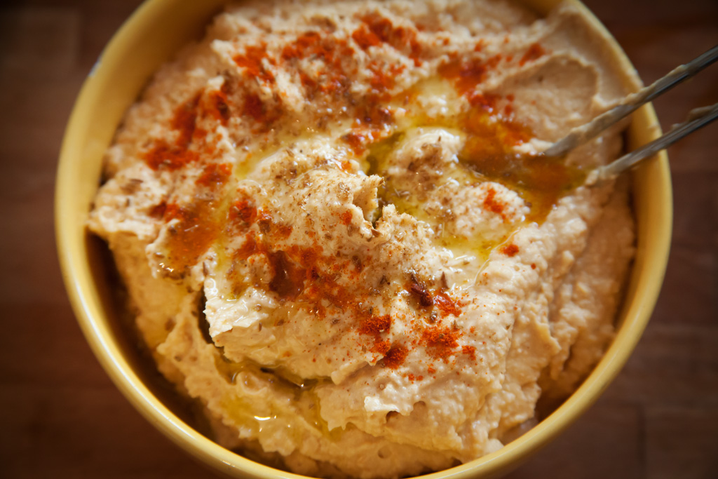 Hummus dekoriert mit Paprika und Olivenöl.