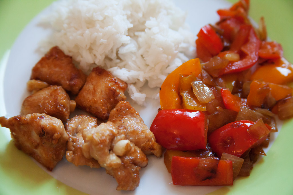 Kross gebratenes Hühnchenfleisch asiatisch gewürzt mit Paprika-Zwiebel-Gemüse.