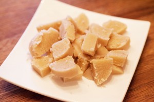 Marzipan Rohmasse wird für die Kokosmakronen in kleinere Stücke geschnitten.