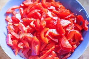Paprika wird in Stücke geschnitten.
