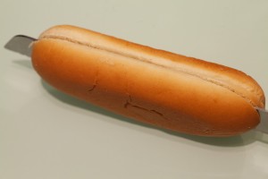 Passende Hot Dog Brötchen werden ungefähr bis zur Mitte eingeschnitten.