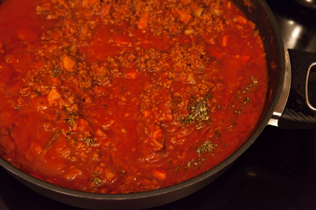 Passierte Tomaten Lorbeerblätter und Italienische Kräuter kommen hinzu.